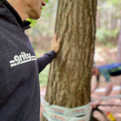 navy grity hoodie by a tree